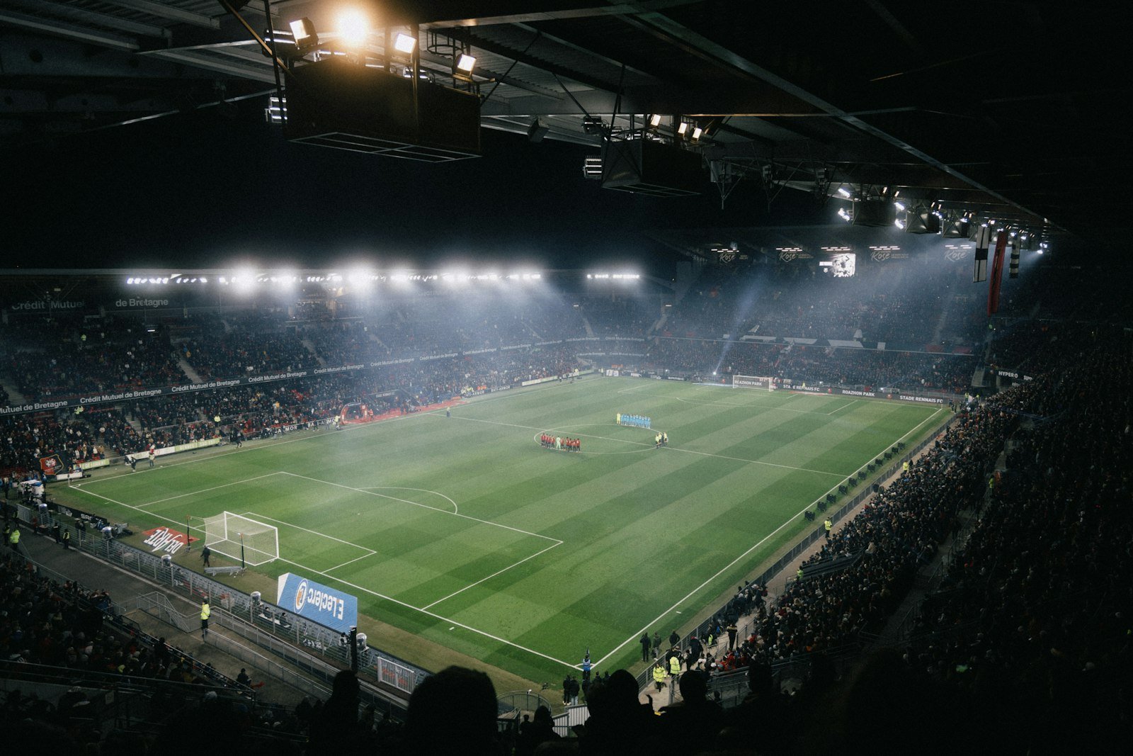 A football stadium under floodlights at night, illustrating an article on decentralised dispute resolution and VAR